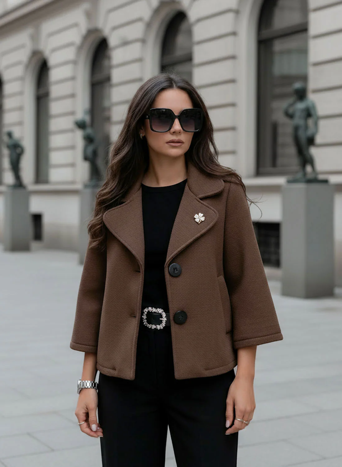 Cappotto corto marrone con bottoni neri e spilla